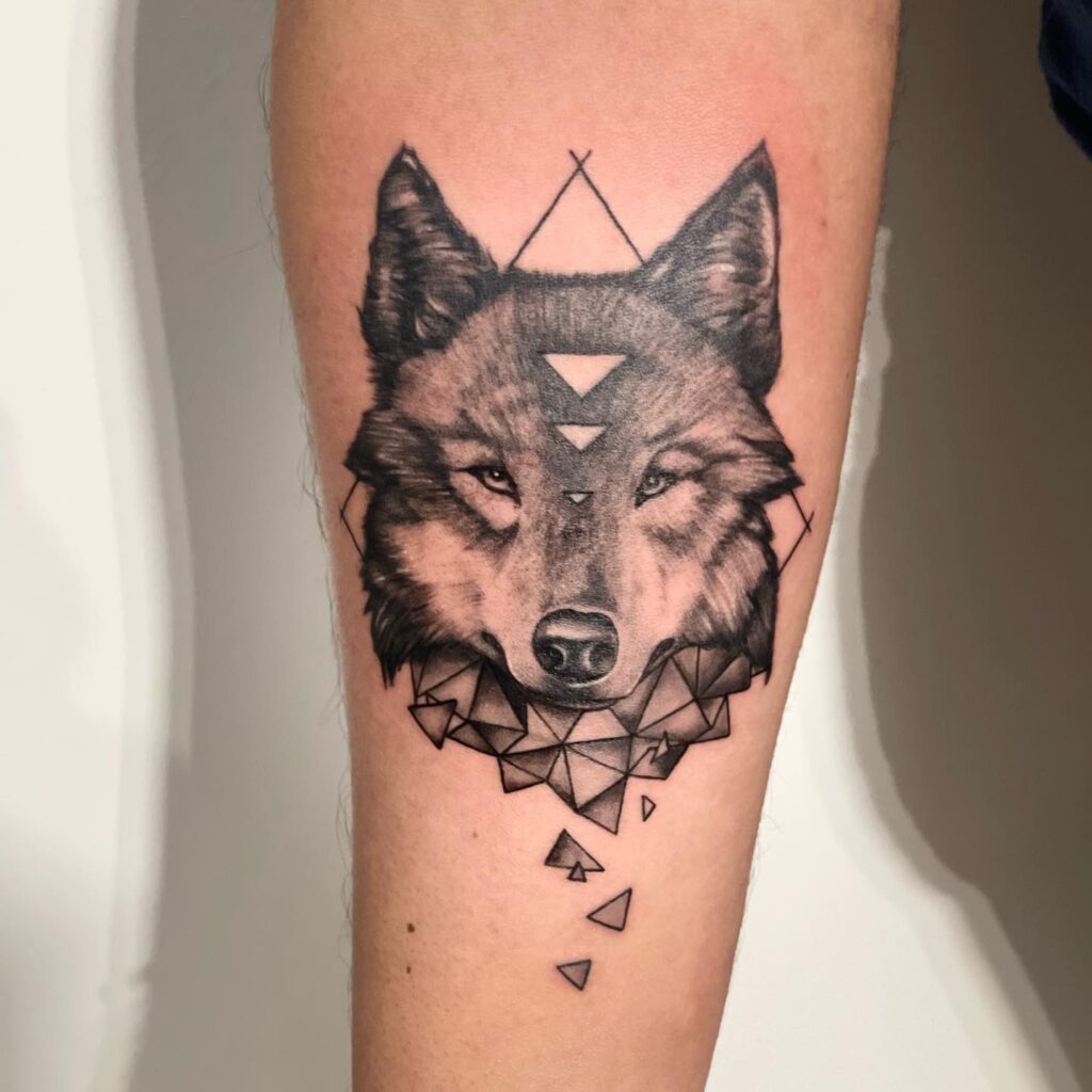 Realistic black and grey wolf tattoo on forearm