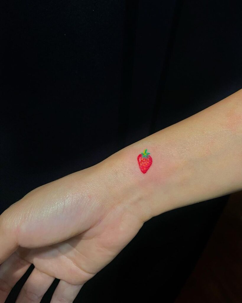 Realistic colorful strawberry wrist tattoo small fruit design bursting with vibrant hues