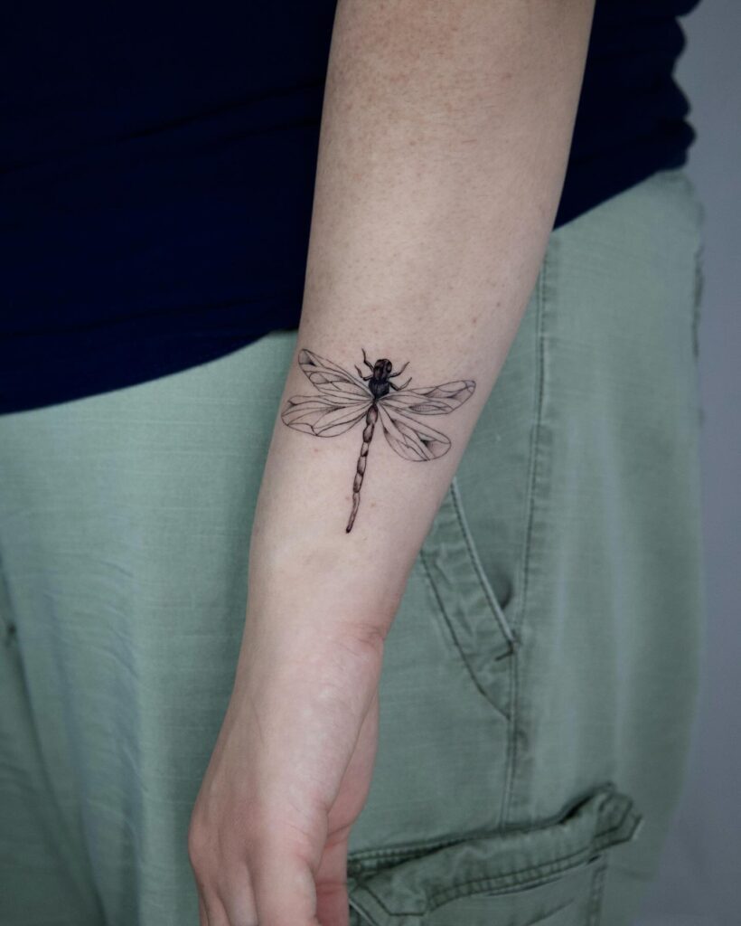 Realistic Dragonfly Tattoo on Forearm Detailed and Lifelike Ink