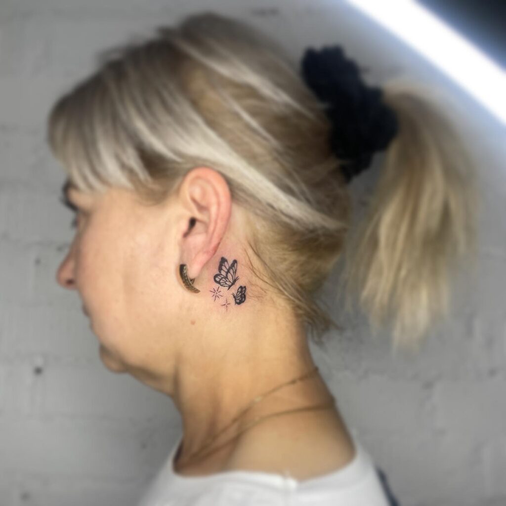 Realistic duo two flying monarch butterflies behind the ear