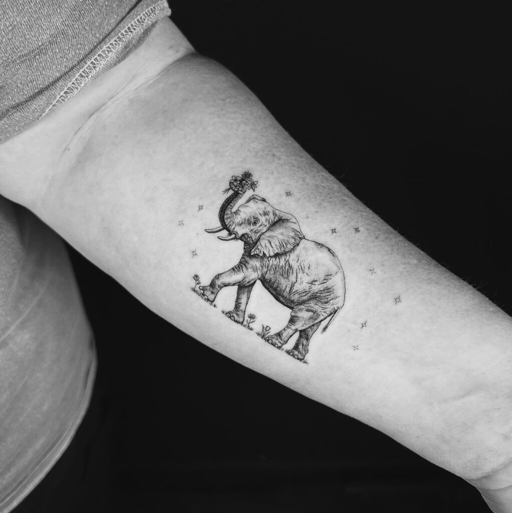Realistic grey shaded elephant on the forearm: starry serenity in ink