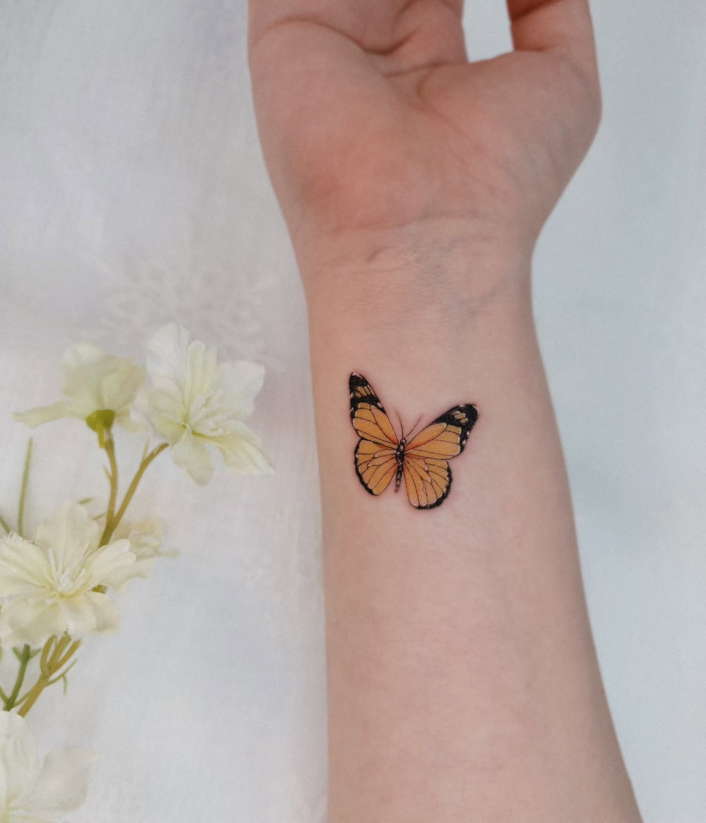 Realistic monarch butterfly tattoo on wrist elegant eye catching