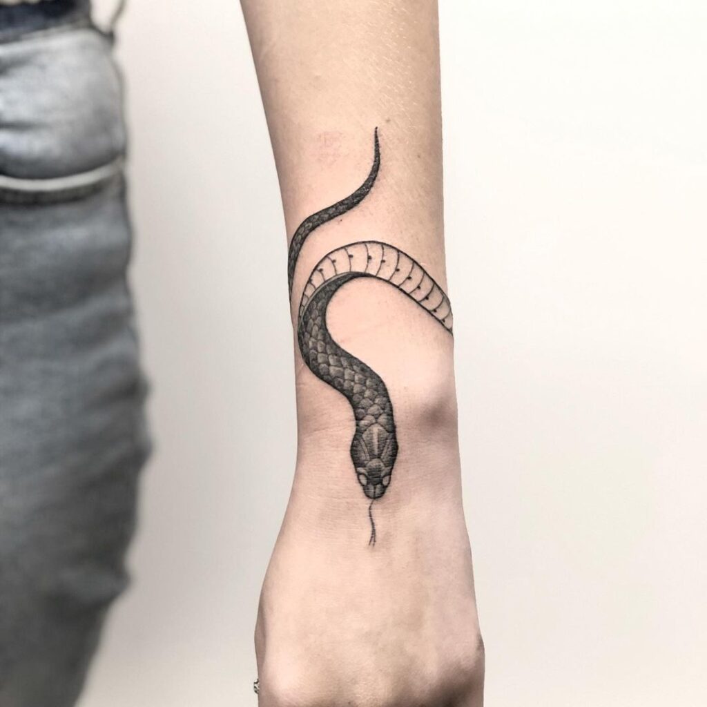 Realistic snake wrapping around wrist tattoo a bold serpent