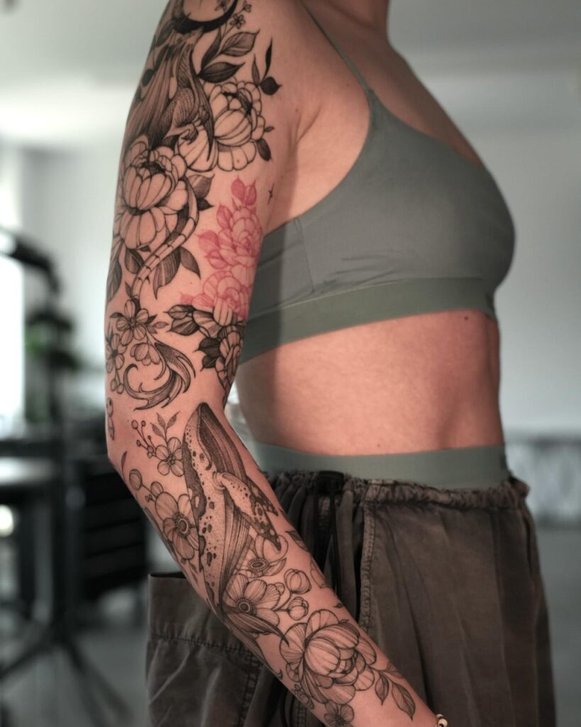 Realistic whale and floral tattoo sleeve with soft shading and deep symbolism