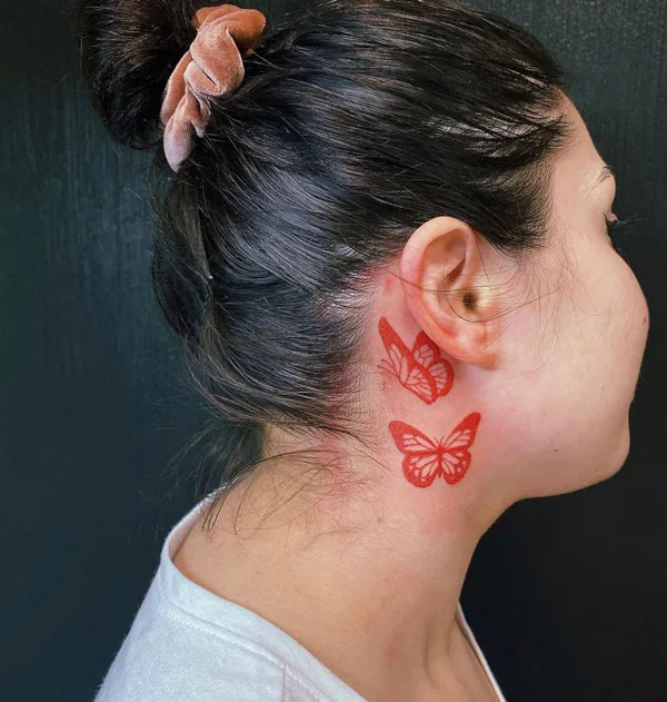 Red butterfly tattoo behind ear