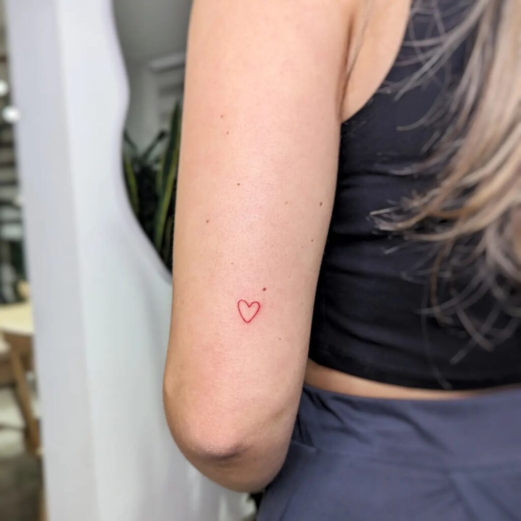 Red Color Outline Heart Tattoo on the Back of the Above the Elbow: Passionate Love