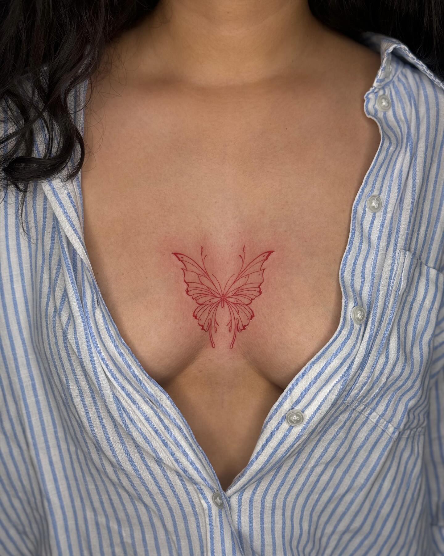 Red ink butterfly tattoo center chest meaning and design inspiration