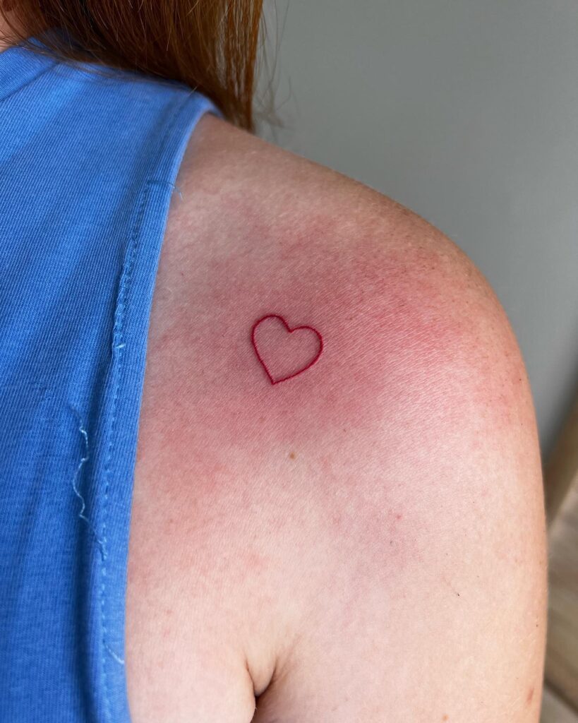 Red outline heart tattoo symbolism on arm and shoulder