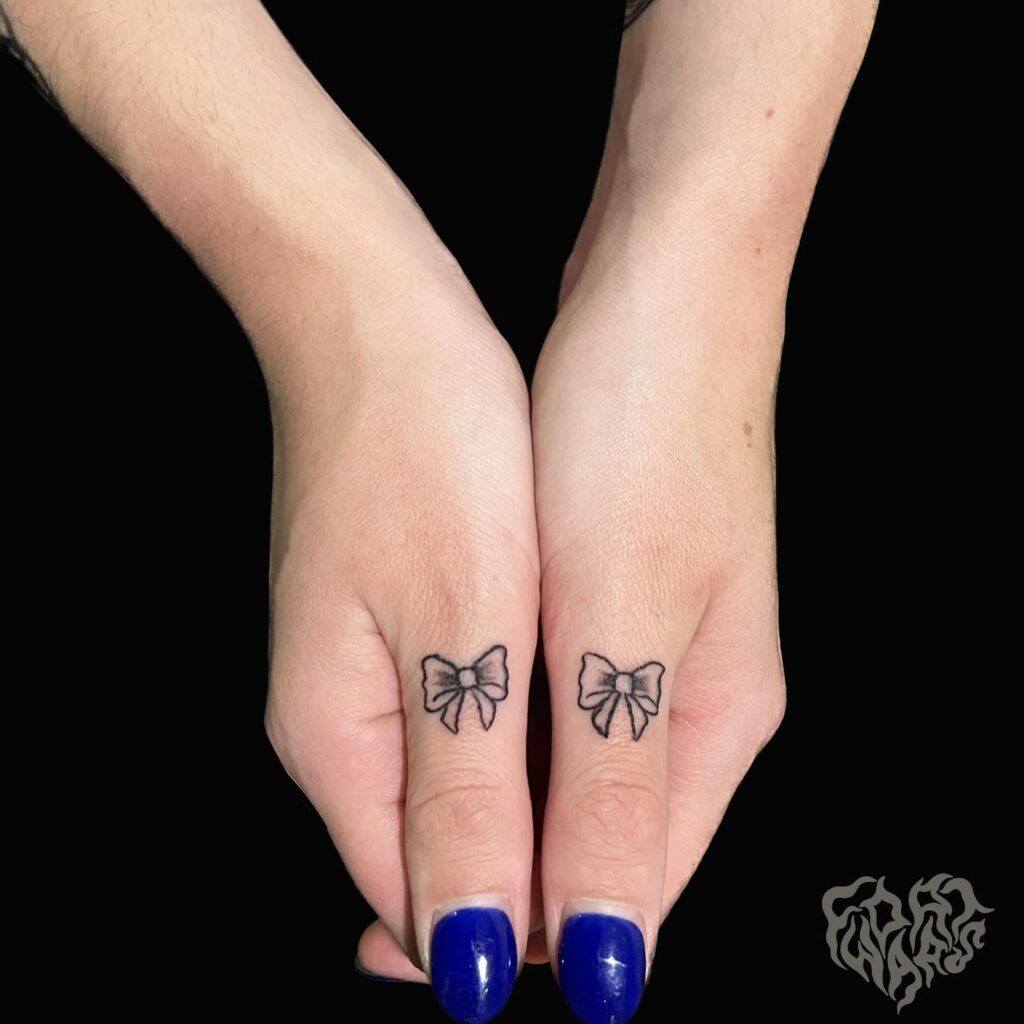 Ribbon Tattoos on Both Thumb and Finger Creating a Harmonious and Chic Look Symmetrical Ribbons