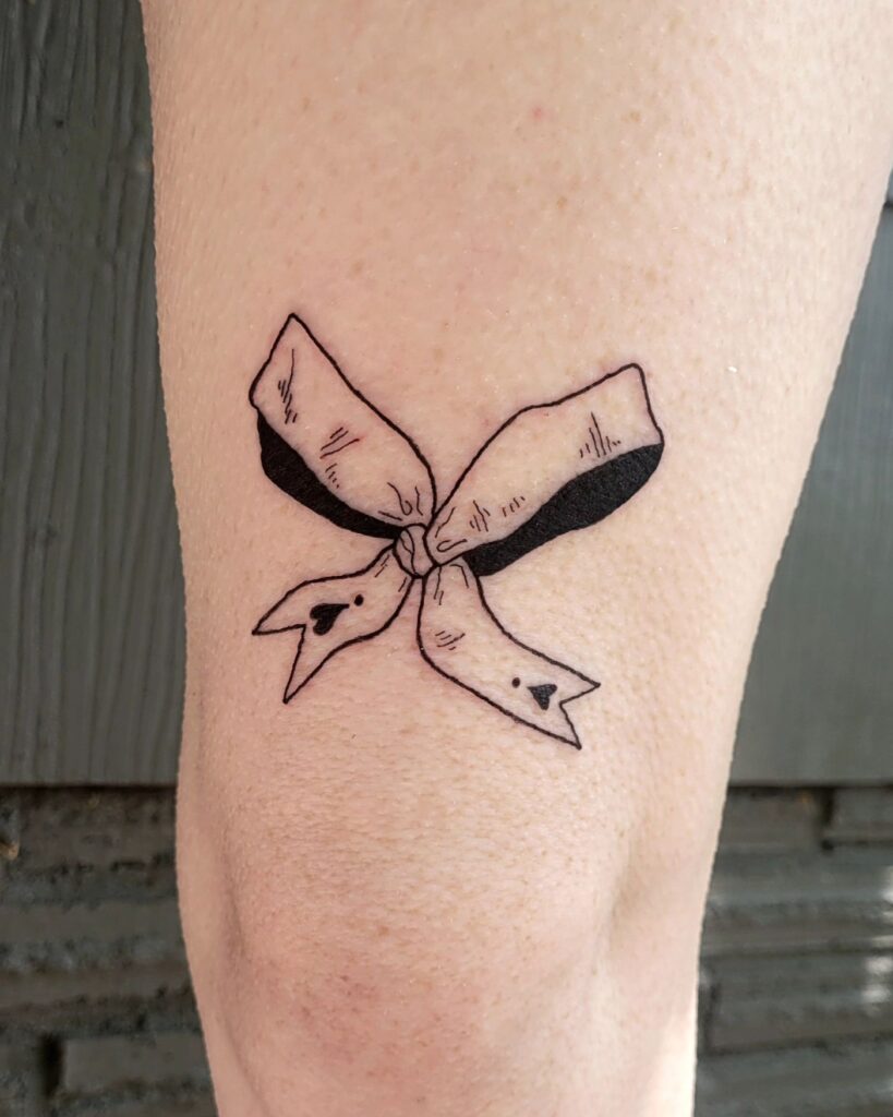 Ribbon of hope a cute above-knee tattoo idea for women