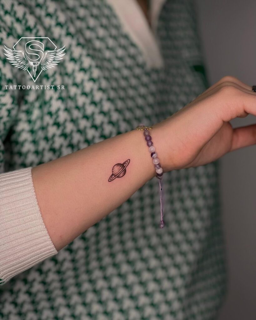 Saturn Tattoo Adorning the Side of the Forearm with Subtle Charm: Celestial Touch