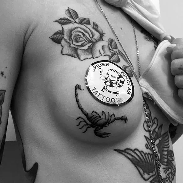 Scorpion under boob tattoo