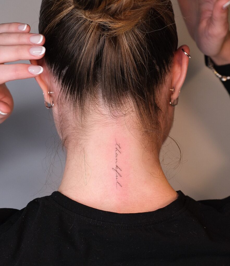 Script 'Thankful' Lettering Vertically Aligned on the Back of the Neck: Ethereal Gratitude