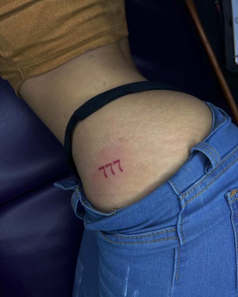 Striking Red 777 Number Tattoo Above the Buttock: Sensual Curve 