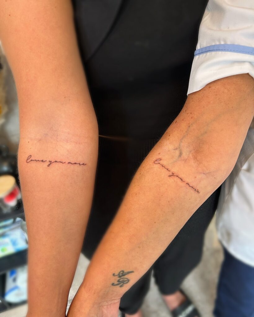 Sentimental "Love You More" cursive tattoo as a mother-daughter tribute