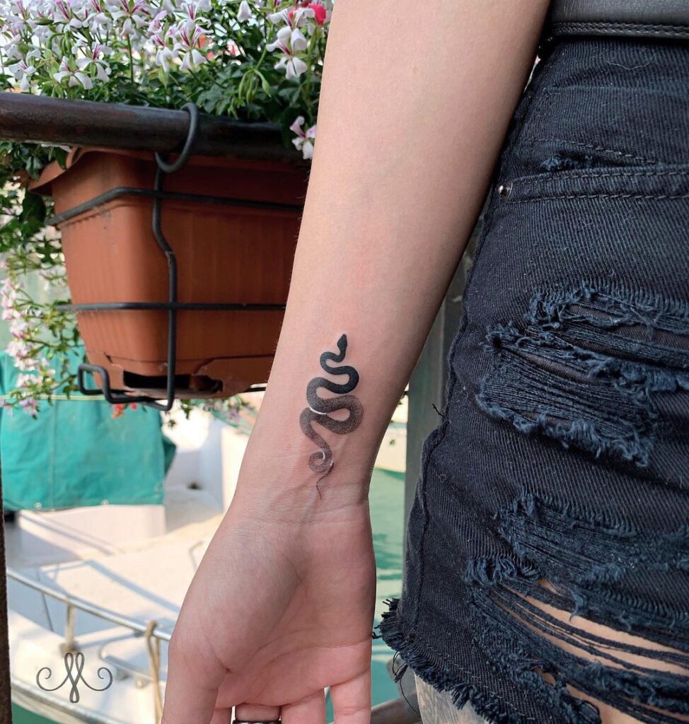 Serpentine beauty a sleek snake tattoo for women on the wrist