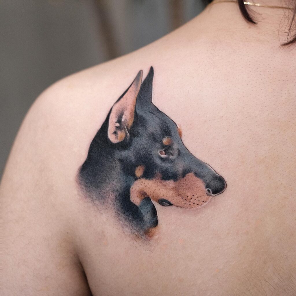 Side View Face Tattoo on the Back of the Shoulder for a Sleek Look: Doberman Elegance