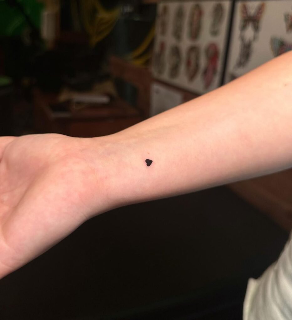 Simple and elegant filled black heart wrist tattoo for timeless chic