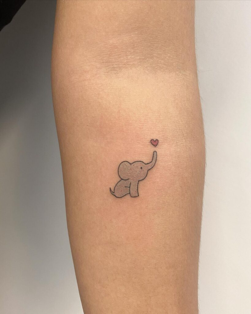 Simple baby outline character elephant tattoo on forearm, trunk up sending a red small heart sweet innocence