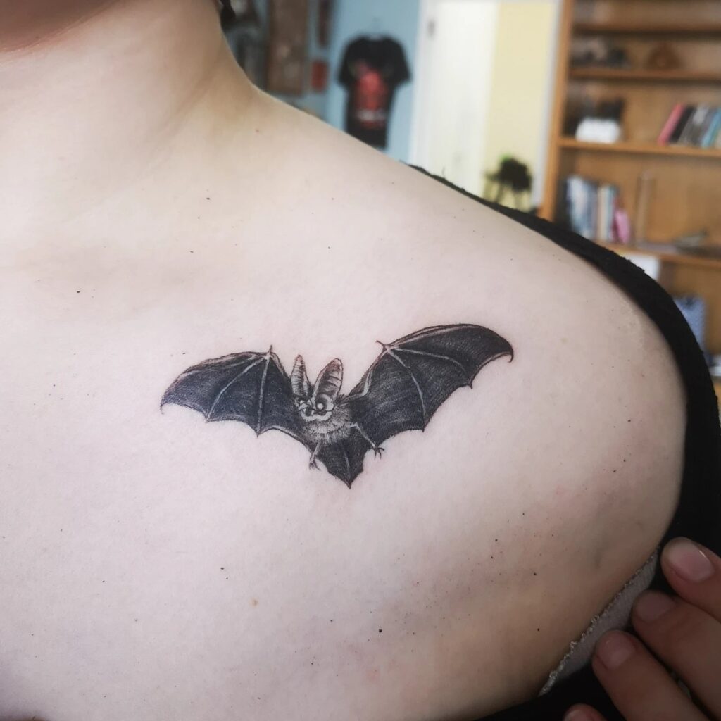 Simple bat tattoo on the collarbone, a bold blackwork statement nocturnal whispers