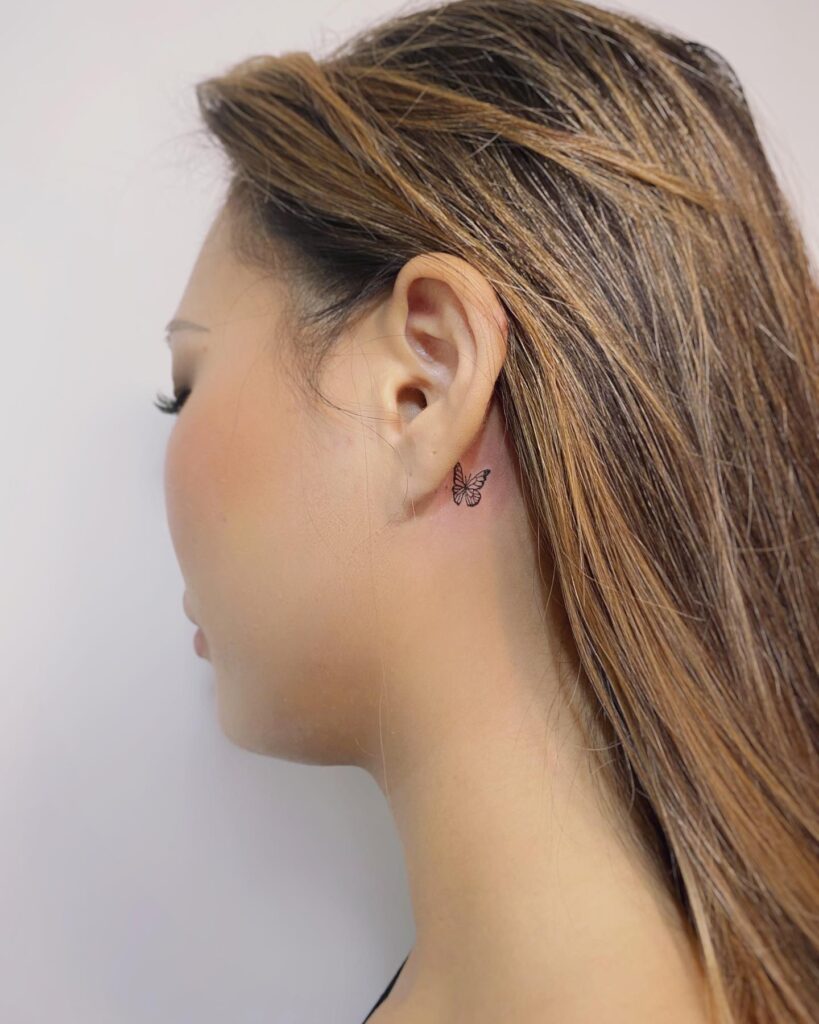 Simple small butterfly behind ear tattoo girl feminine grace
