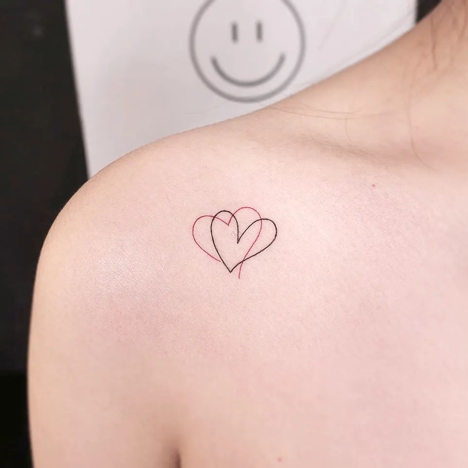 Simple thin lined red and black collarbone tattoo: two hearts harmony