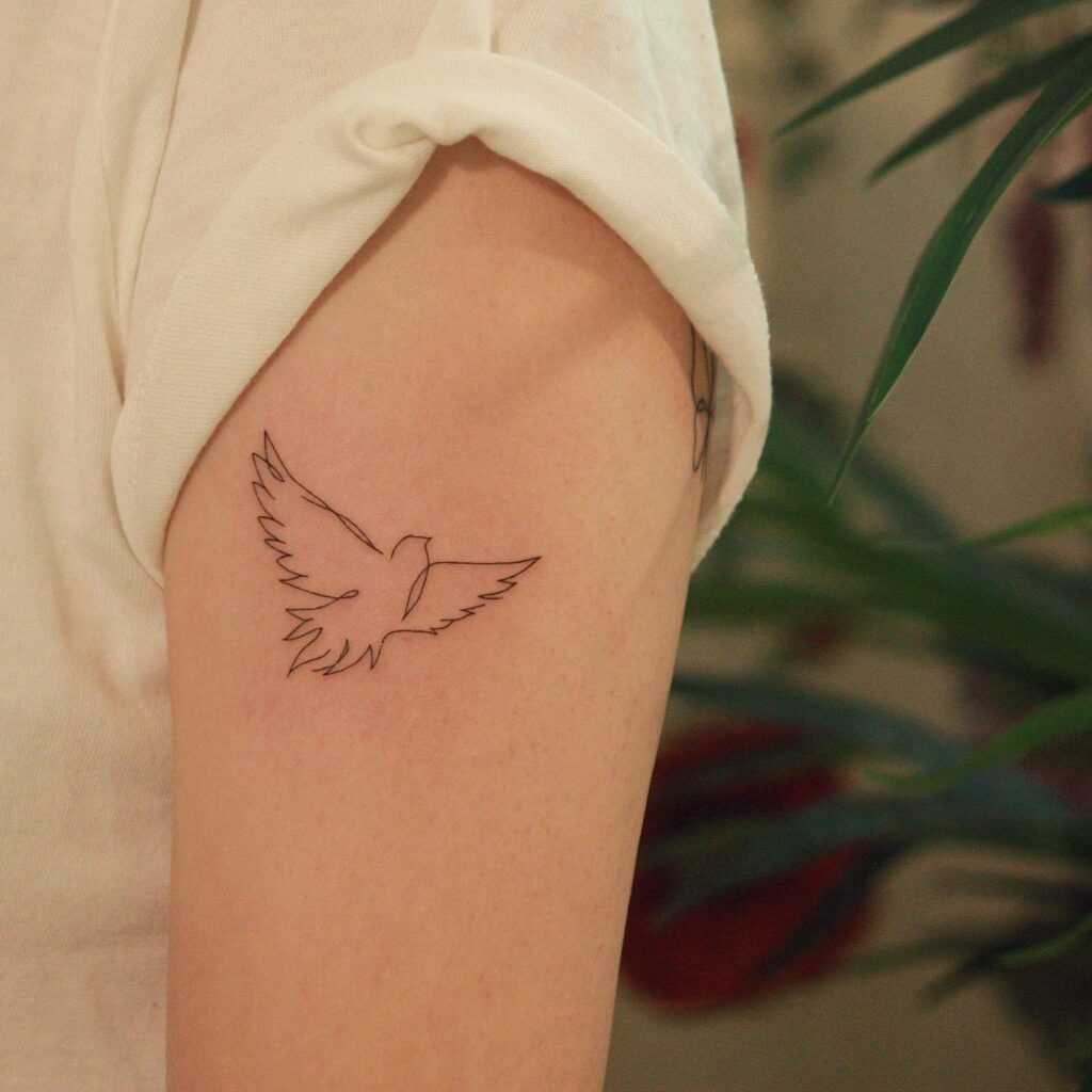 Single Bird Fineline Tattoo on the Outer Arm: Avian Grace