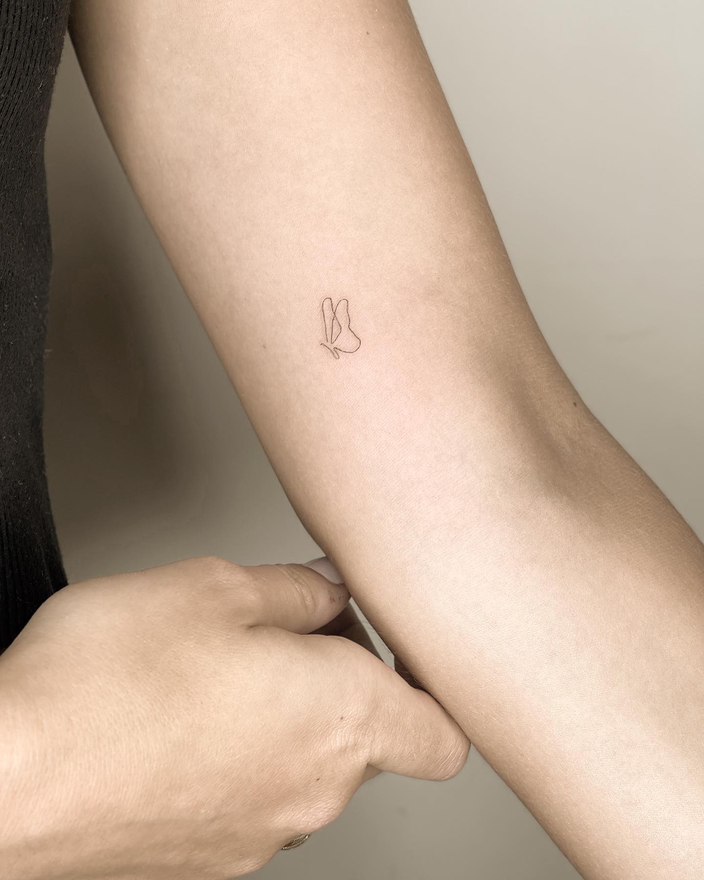 Single line butterfly tattoo inner forearm with minimalist aesthetic
