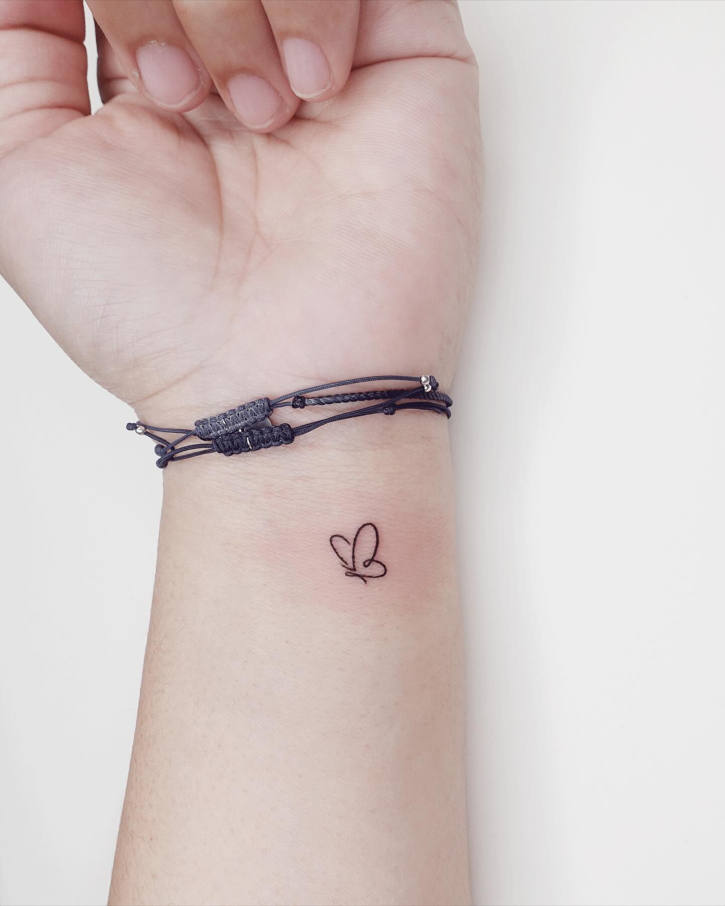 Single line butterfly tattoo on inner wrist for emotional transformation