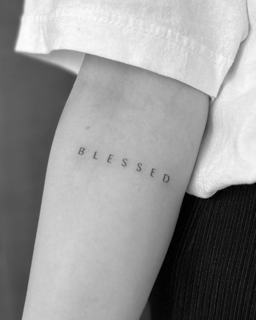Single needle 'blessed' tattoo thin lettering with artistic spacing