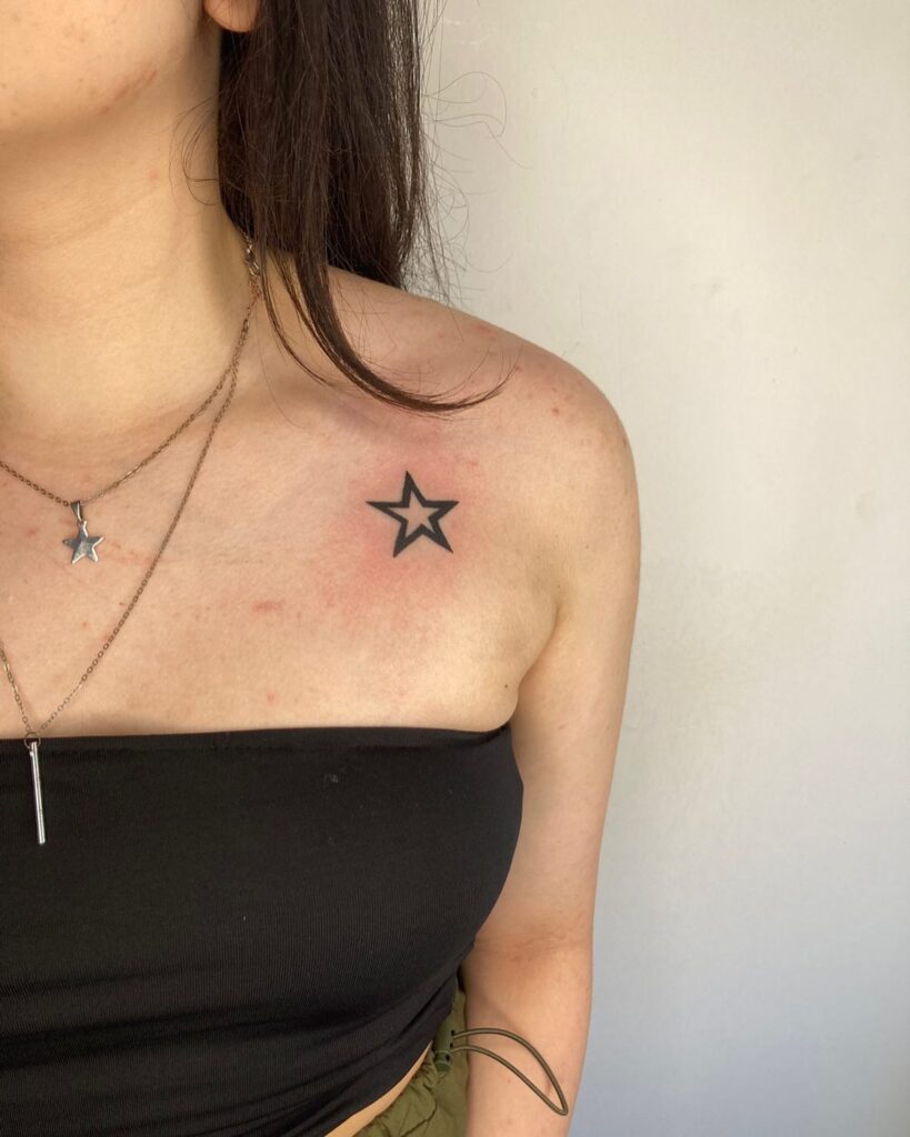 Single outline star tattoo on female shoulder