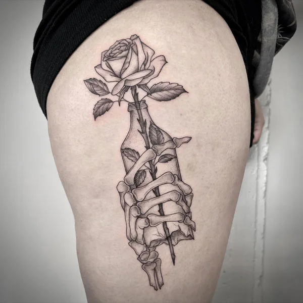 Skeleton hand tattoo on thigh
