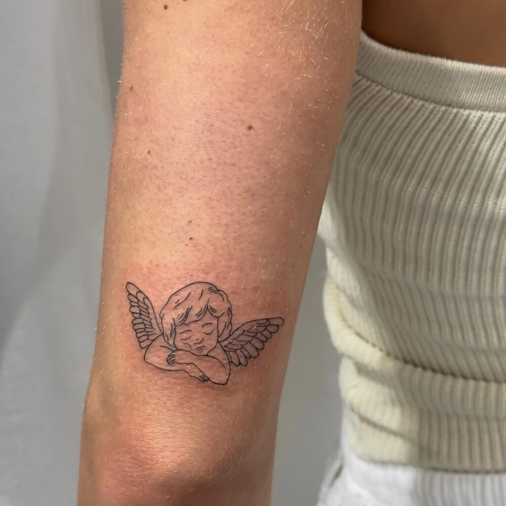 Sleeping Baby Angel with Wings Tattoo on the Back of the Elbow: Sweet Dreams
