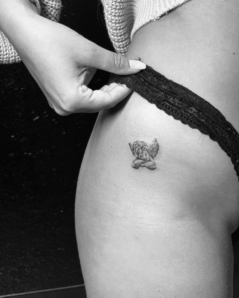 Sleepy Baby Angel Tattoo on the Hip: Minimalistic Slumber