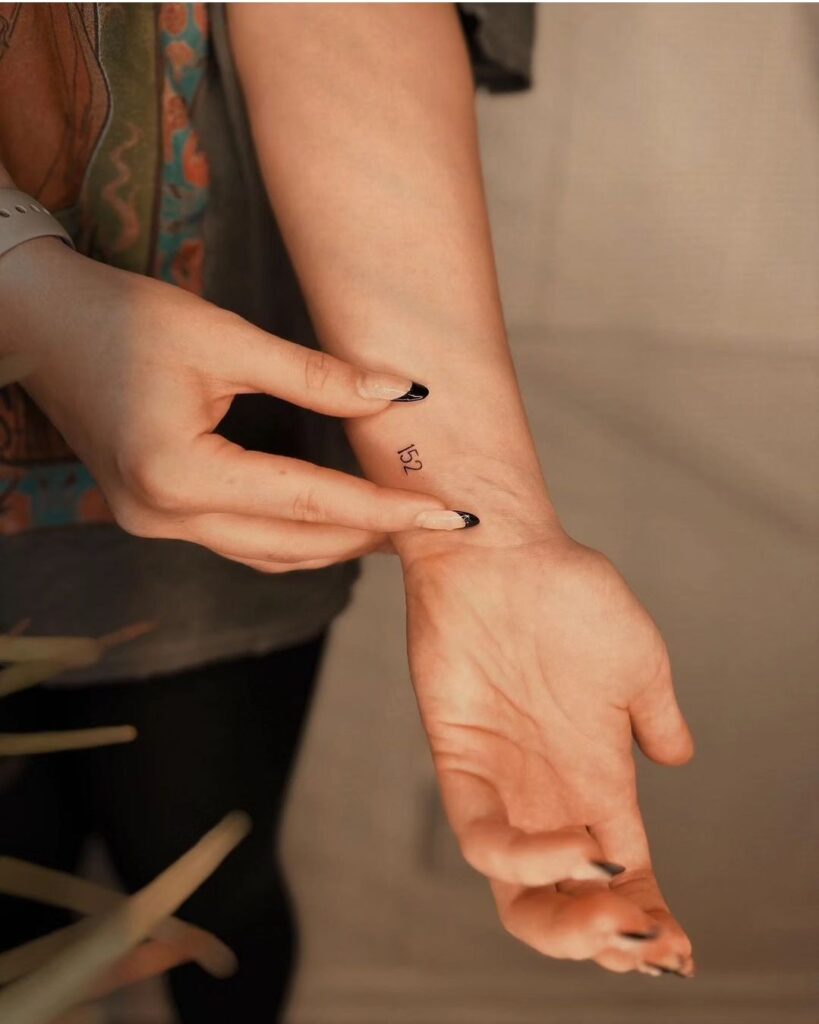 Small 152 number wrist tattoo vertical elegance on the inner wrist