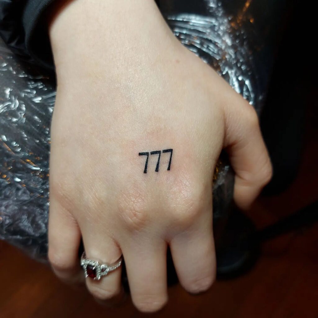 Small 777 Tattoo on the Outer Hand for a Delicate Statement: Hand Whispers 