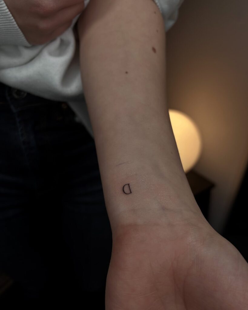 Small 'D' Letter Tattoo on the Inner Wrist: Feminine Touch