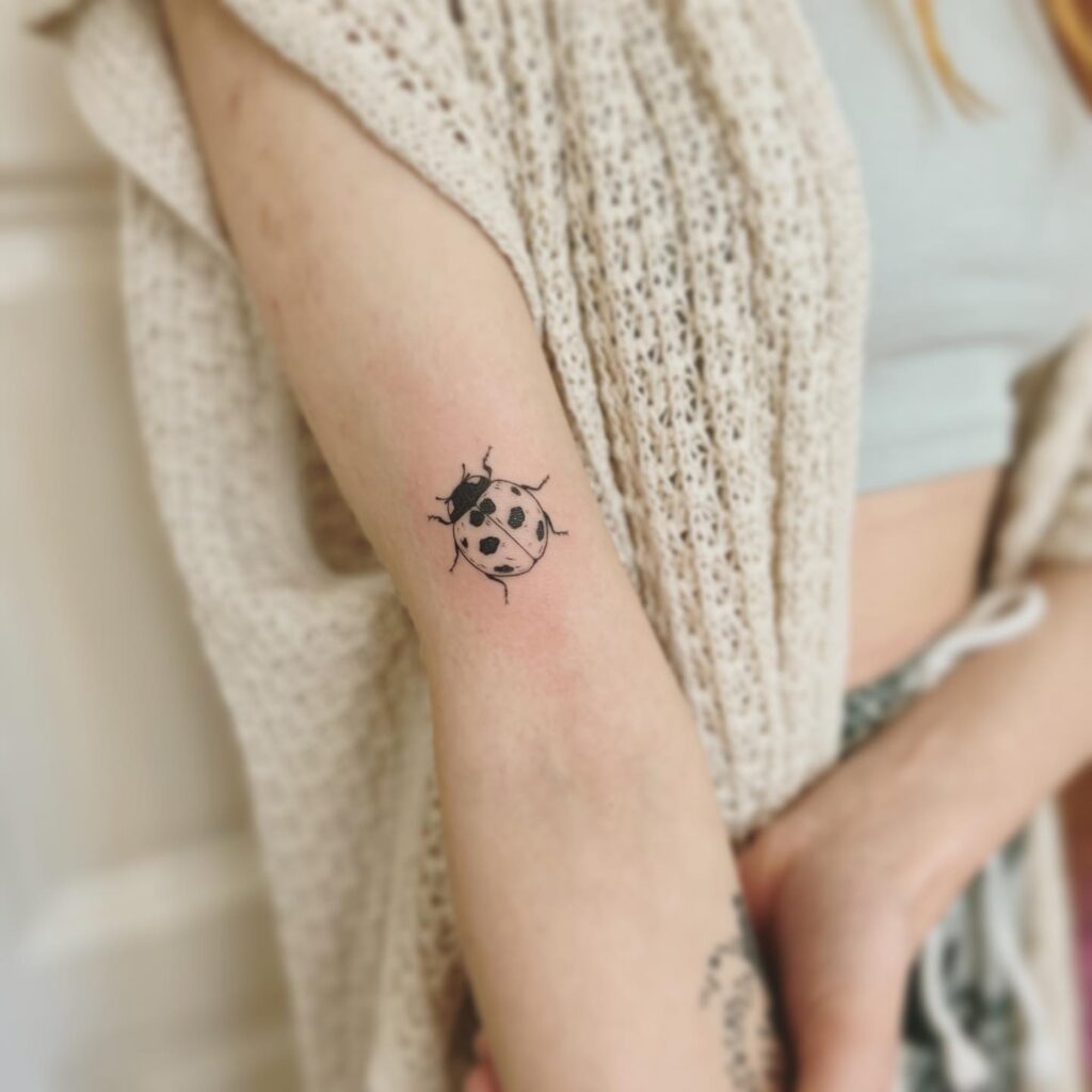 Small Ladybug Tattoo Above Elbow Placement for Females Delightfully Dainty and Meaningful
