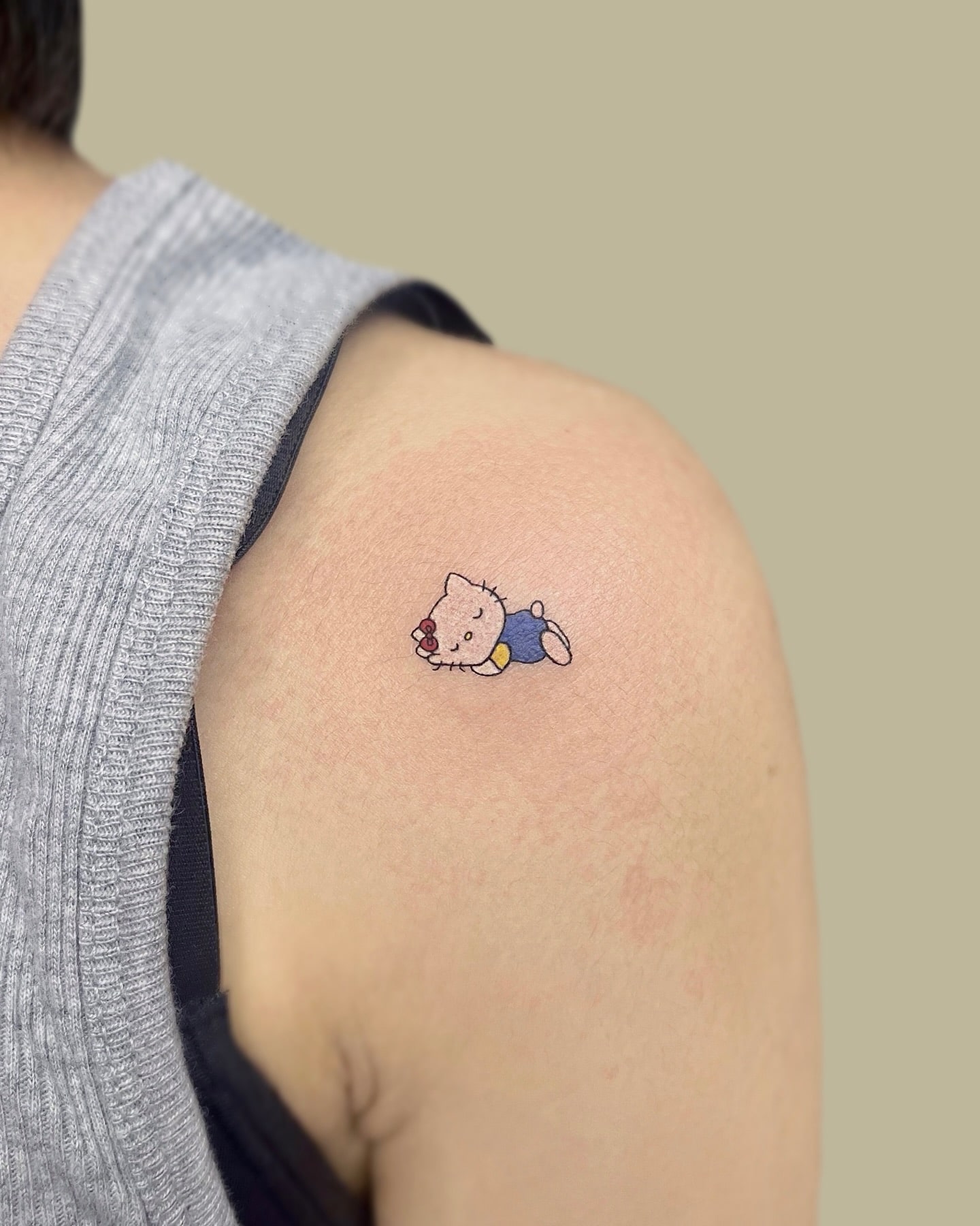 Small and colorful Hello Kitty tattoo with soft pastel tones and playful details, great for those who cherish childhood memories and kawaii aesthetics