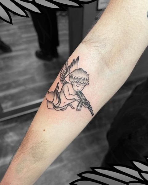 Small baby angel with gun tattoo