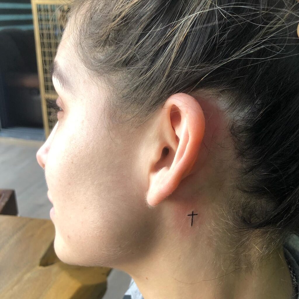 Small behind the ear tiny cross tattoo idea for girl