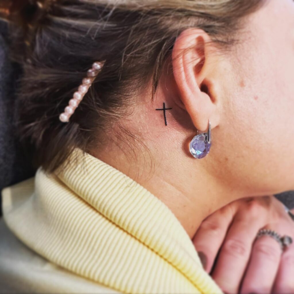 Small cross feminine cross tattoo behind ears