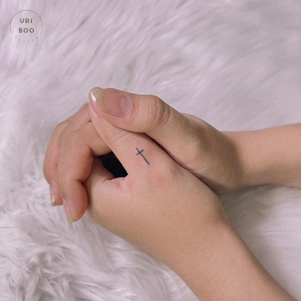 Small Cross Tattoo on the Thumb, a Dainty and Symbolic Addition: Thumb Elegance