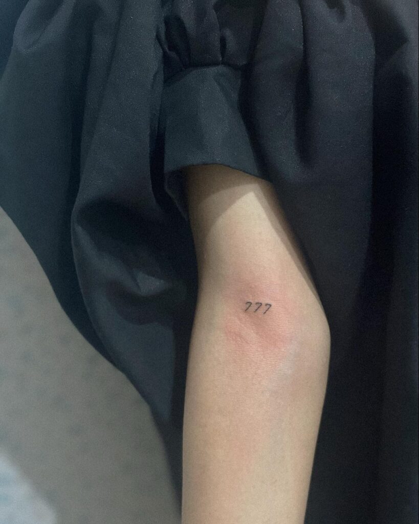 Small Fineline 777 Tattoo on the Elbow: Wisdom in Digits 