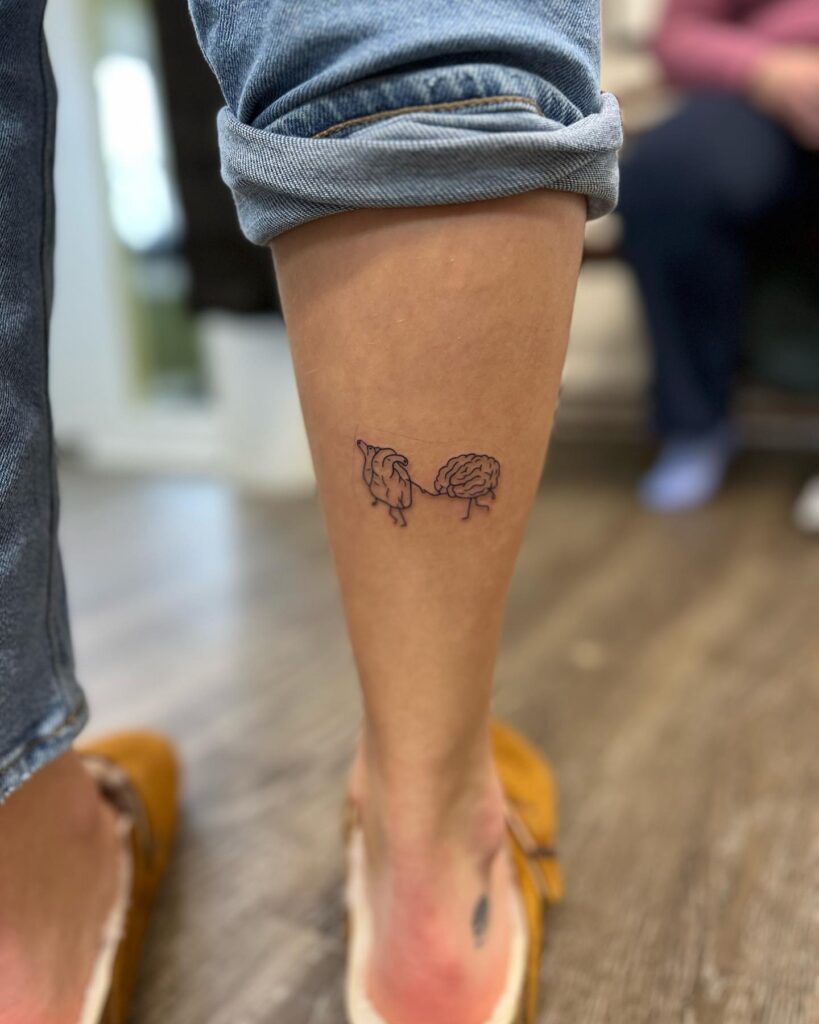 Small Fineline Heart Leading the Brain Tattoo on the Calf: Heart and Mind Sync