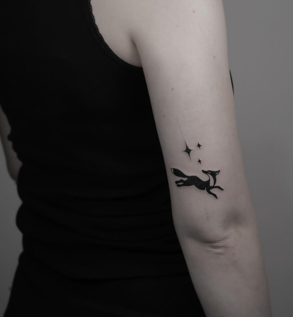 Small Fox Tattoo with North Star Above the Elbow, a Celestial Touch: Starry Perspective