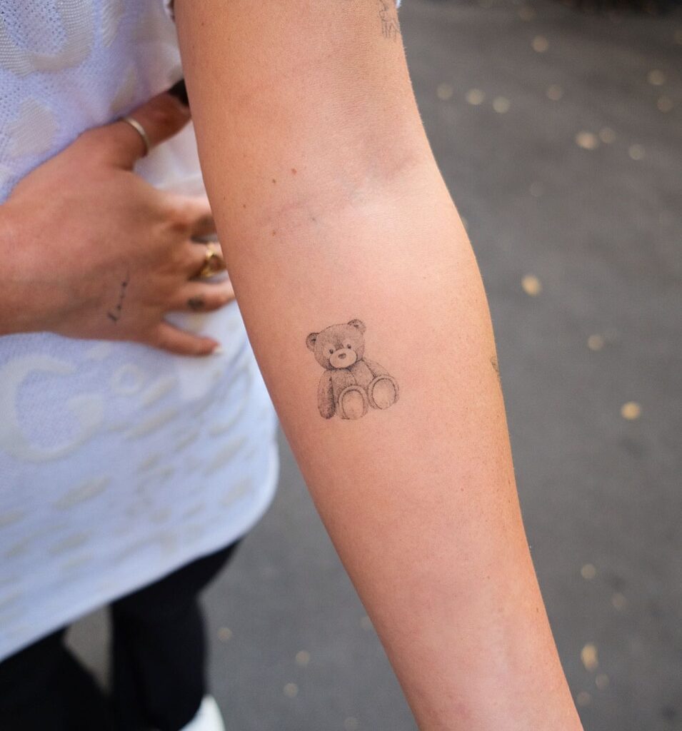 Small healed teddy bear tattoo on the forearm teddy's embrace