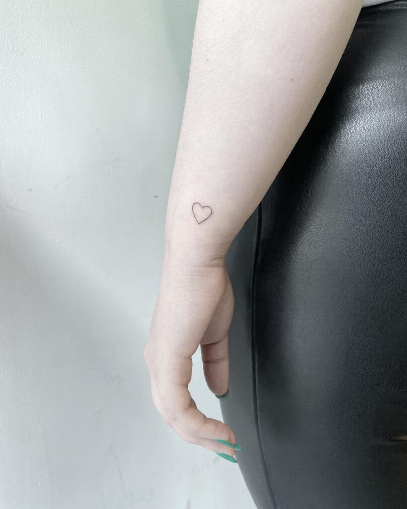 Small heart tattoo on side of wrist dainty and delicate