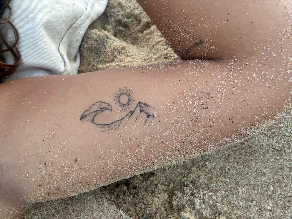 Small inner bicep sun and ocean tattoo hidden charm