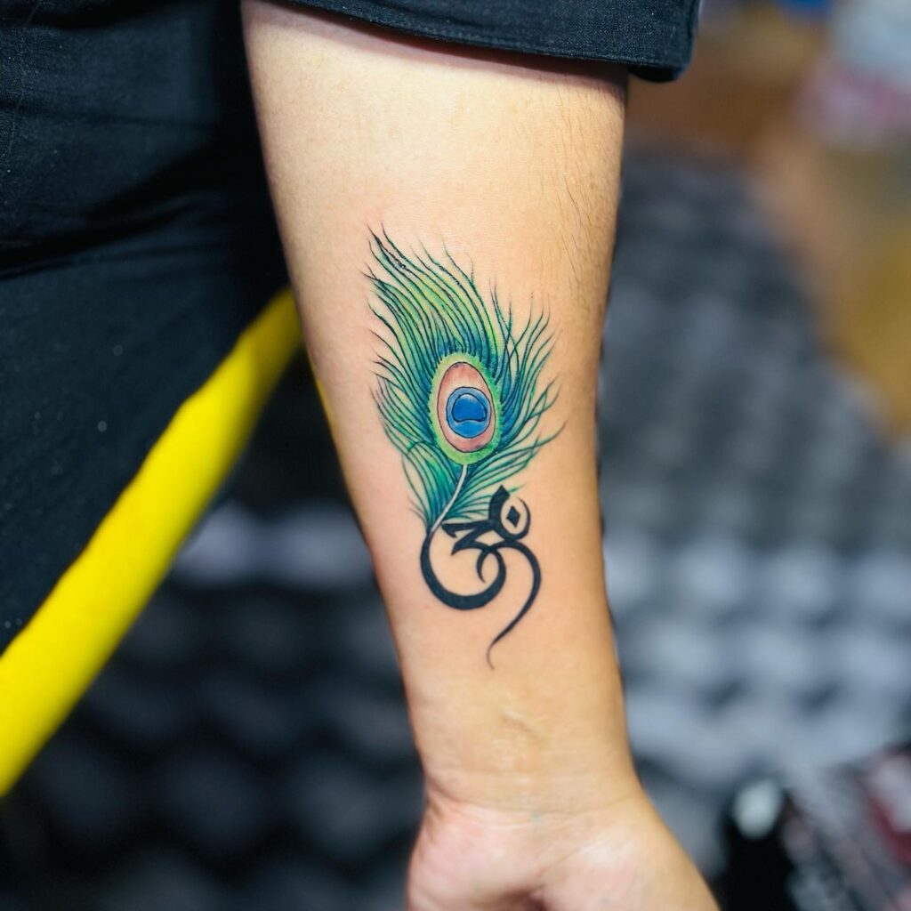 Small Inner Wrist Peacock Feather and Om Symbol Tattoo Design : Spiritual and Elegant